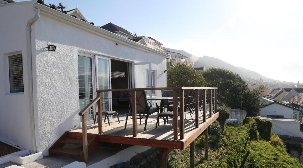 a balcony with a table and chairs on a house at Apartment The Nook in Fish hoek