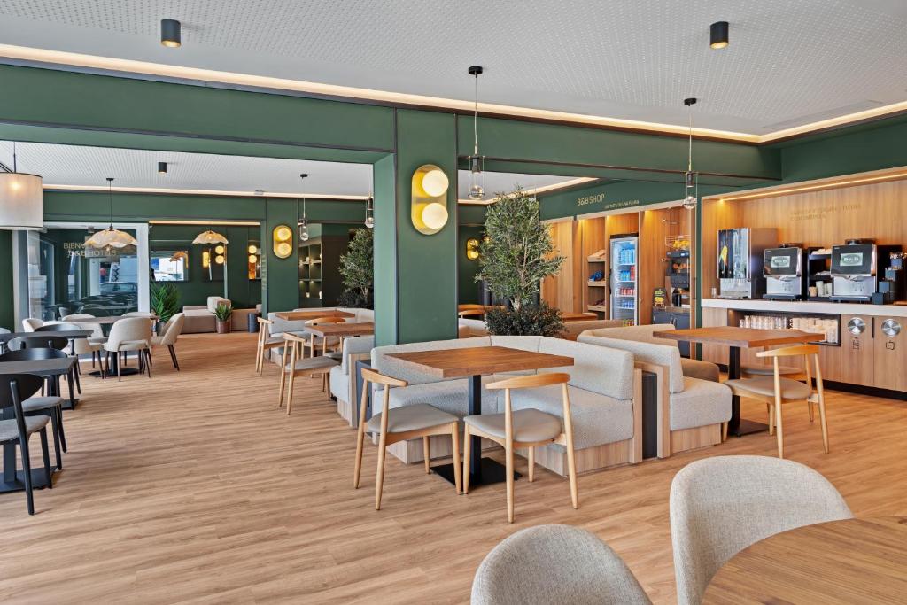 a restaurant with tables and chairs in a cafeteria at B&B HOTEL Santiago Milladoiro in Milladoiro