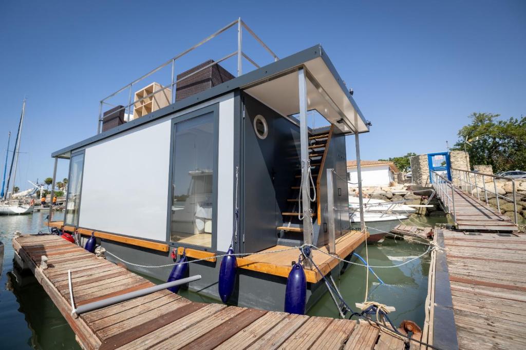 圣玛丽亚港The Boathouse Company - Casa flotante experience - Real Club Náutico, El Puerto de Santa María的一艘小船停靠在码头