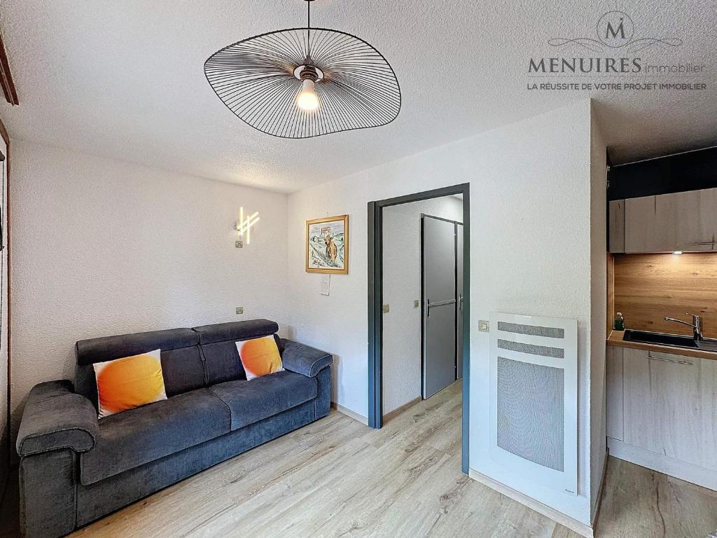 a living room with a couch and a kitchen at Studio + cabine 4 pers 24m², ski aux pieds, parking à proximité - FR-1-178-106 in Les Menuires