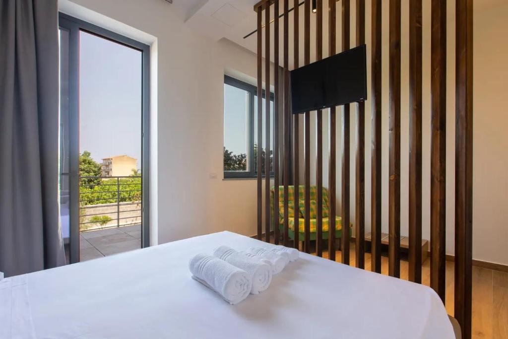 a bedroom with a white bed with towels on it at La BriSa in Capo dʼOrlando