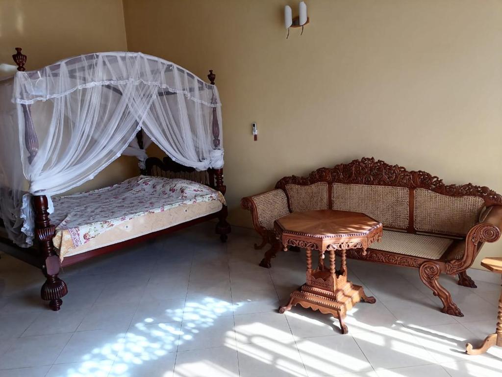 Un dormitorio con dos camas y una mesa dentro. en Sujee Villa CeylonHub, en Beruwala
