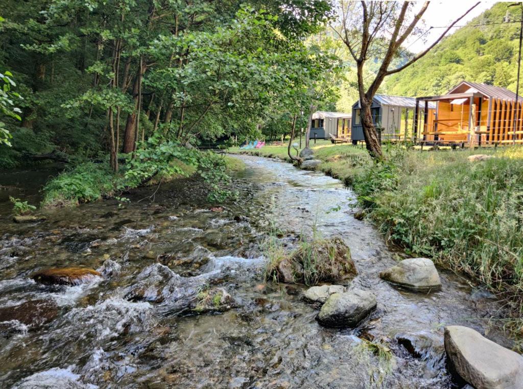 um riacho de água com rochas ao lado de um comboio em Transfăgărășan River Retreat em Arefu