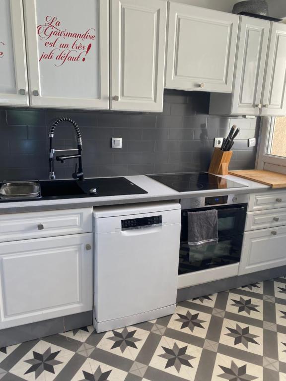 une cuisine avec des armoires blanches et un évier dans l'établissement Très bel appartement bord de mer, à Marseille