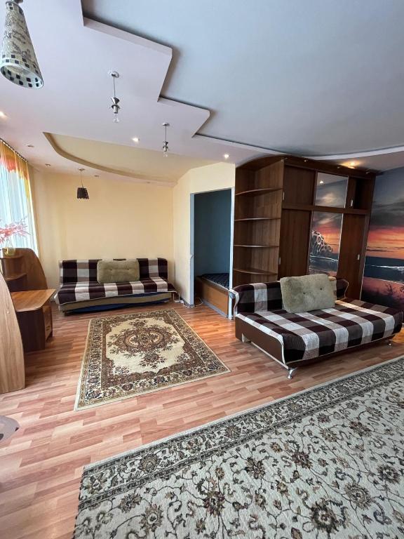 ein Wohnzimmer mit 2 Sofas und einem Teppich in der Unterkunft Двухкомнатная Квартира 5 in Balqasch