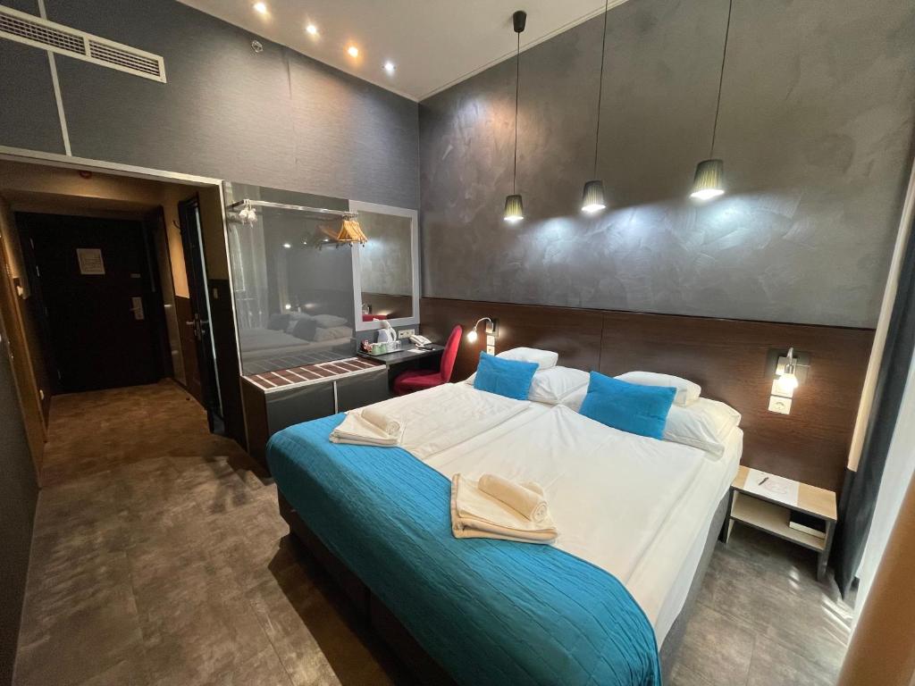 a bedroom with a large bed and a bathroom at Carat Boutique Hotel in Budapest