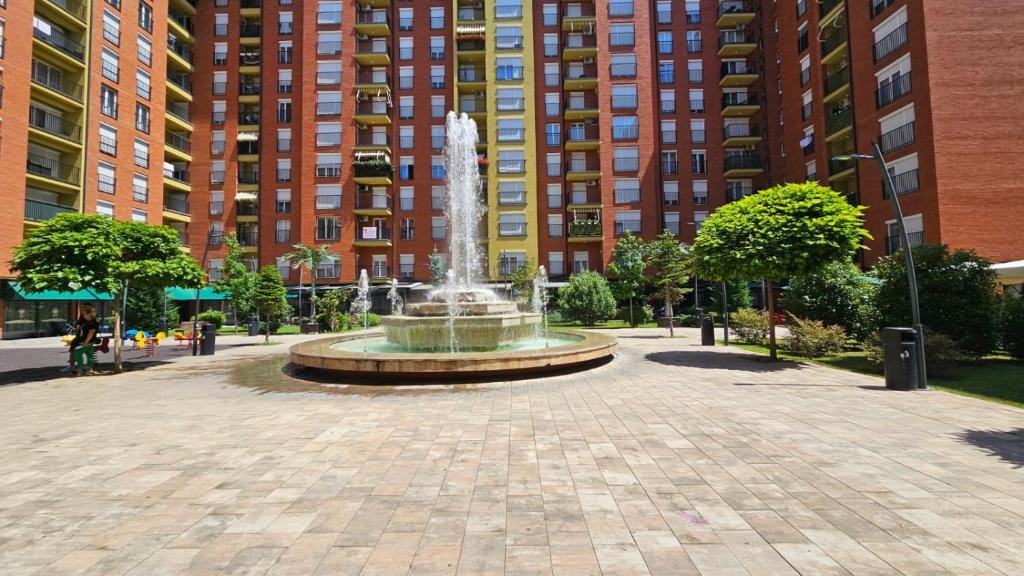 a fountain in the middle of a courtyard with tall buildings at Superb 1 bedroom in the best zone of the city. in Ferizaj