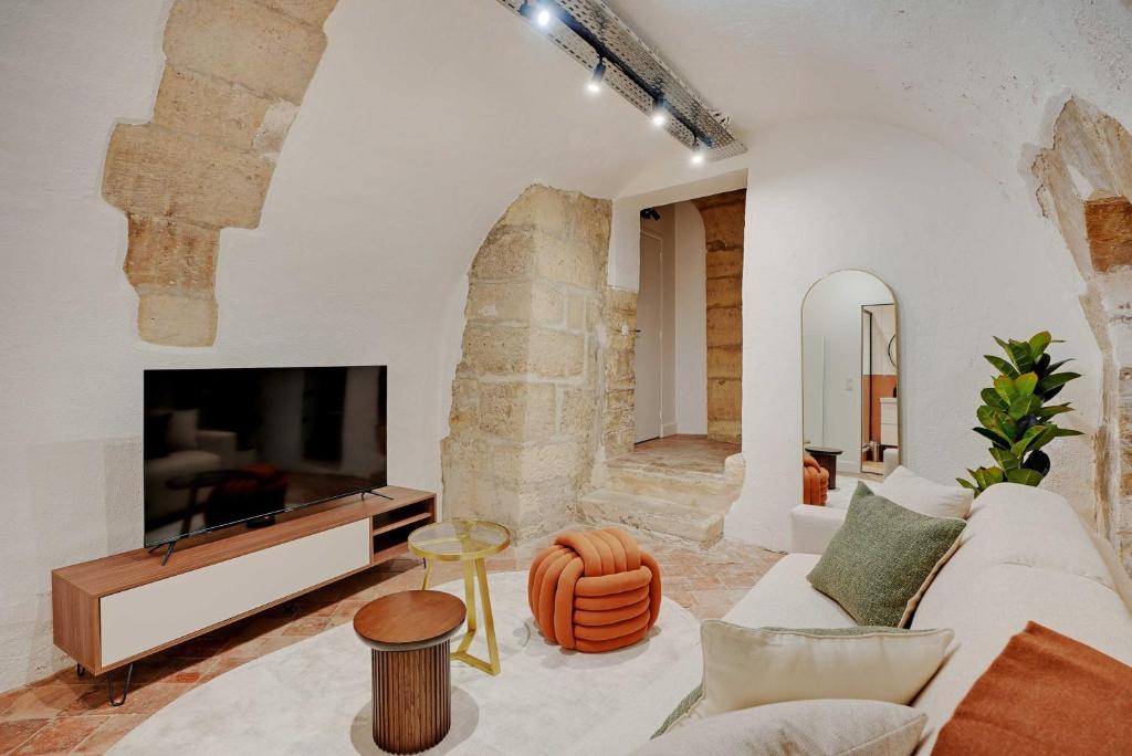 Una sala de estar con un sofá blanco y un televisor. en Magnifique appt avec 2 salons- 1BD-6P - Notre-Dame, en París