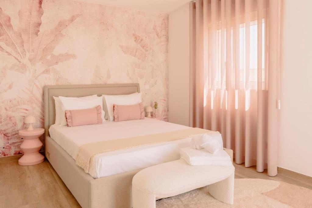ein weißes Schlafzimmer mit einem großen Bett mit rosa Wänden in der Unterkunft Glam House no coração da cidade in Faro