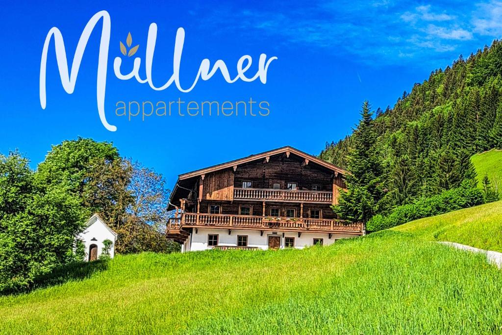 a house on a hill in a green field at Müllner Appartements Historisches Haus mit Bergblick, umgeben von Wäldern & Wiesen in Thiersee