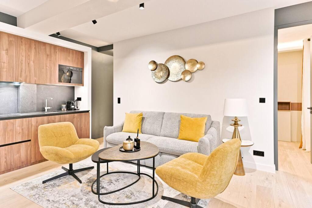 un salon avec un canapé, deux chaises et une table dans l'établissement Magnifique Appartement #Miromesnil #Monceau #Paris, à Paris