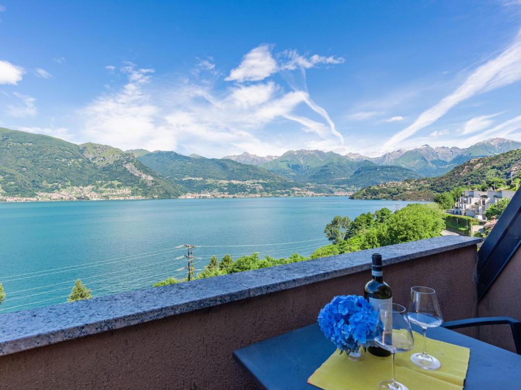 a table with wine glasses and a view of a lake at Apartment Vento Errante by Interhome in Dorio