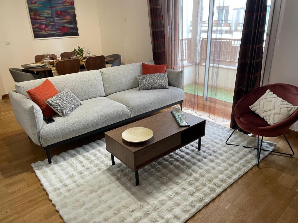 un salon avec un canapé et une table basse dans l'établissement Superbe appartement, 1er étage avec ascenseur, à 5 min du métro avec parking gratuit, au Kremlin-Bicêtre