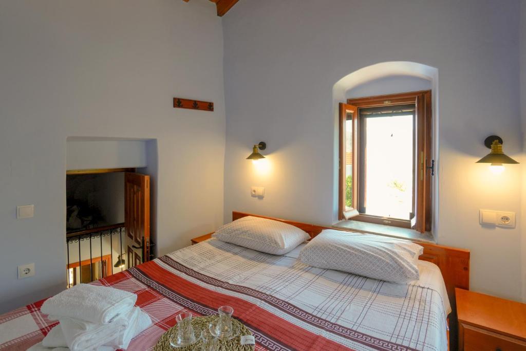 a bedroom with a bed and a window at Symi Uptown Indigo in Symi