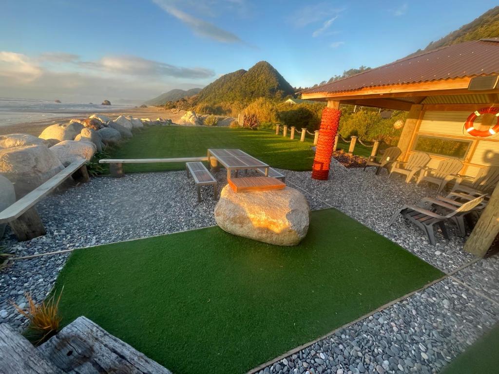 a house with a large rock and green grass at The Ghost Lodge in Granity