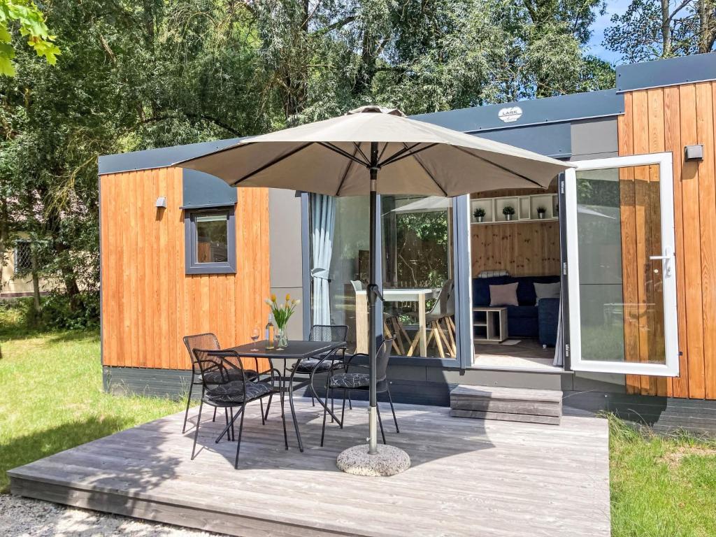 a patio with a table and chairs under an umbrella at Holiday Home Tiny Haus Auszeit by Interhome in Riedenburg