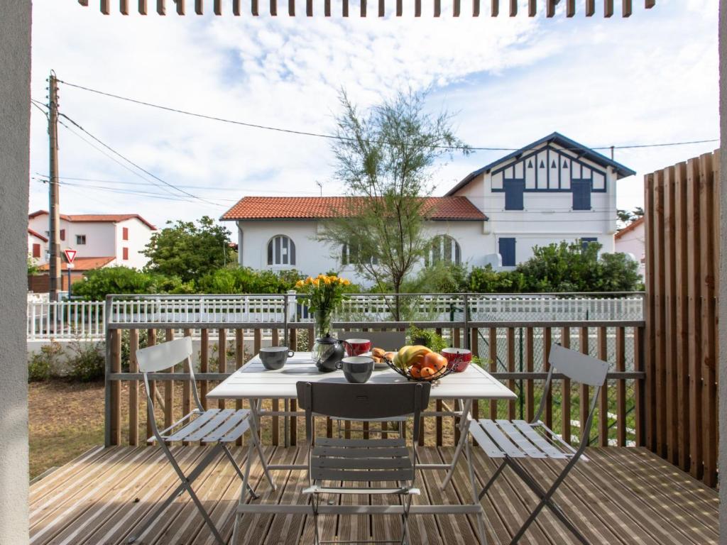 un patio avec une table et des chaises sur une terrasse dans l'établissement Apartment Cap Océan-8 by Interhome, à Capbreton