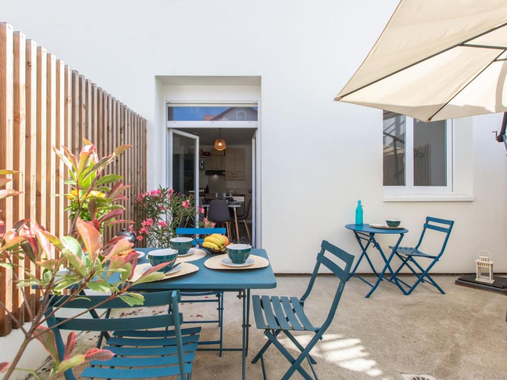 un patio avec une table, des chaises et un parasol dans l'établissement Apartment Cap Océan-9 by Interhome, à Capbreton
