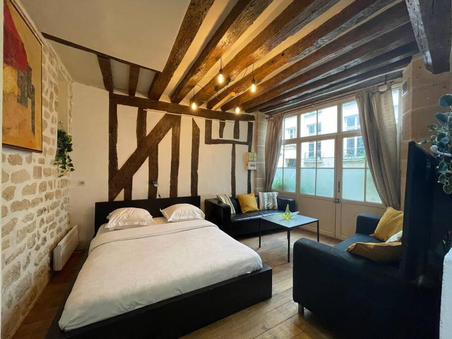 une chambre avec un lit, un canapé et une table dans l'établissement Charming Apt Rue st André des arts, à Paris