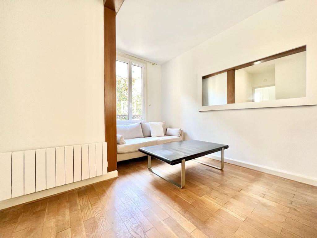un salon avec un canapé et une table dans l'établissement Appartement - Paris 16 - Passy, à Paris