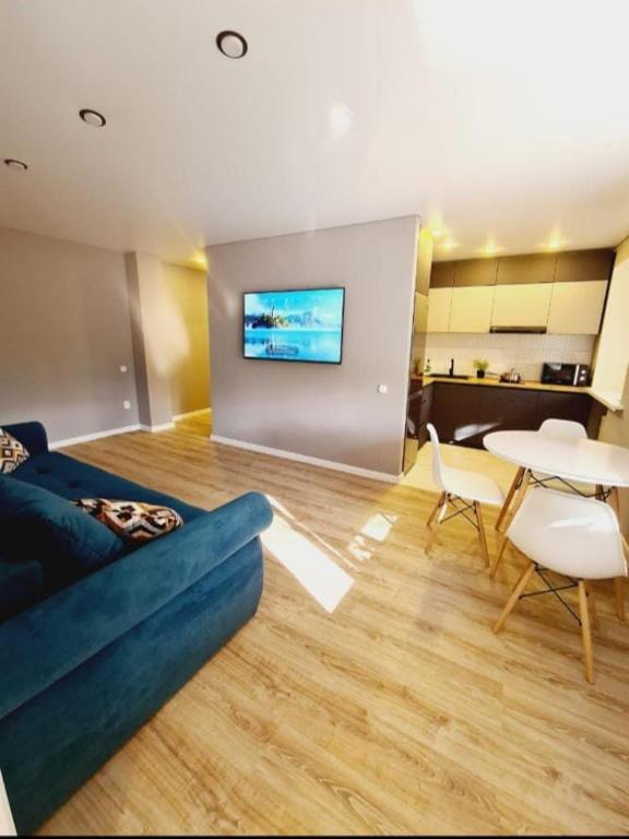 a living room with a couch and a table at Бухар Жирау 44 in Karagandy