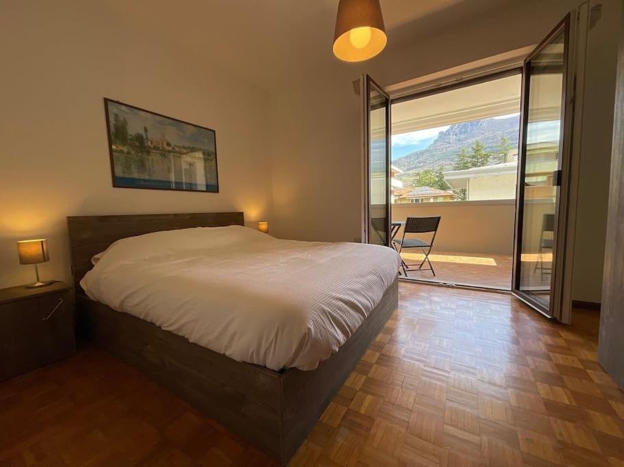 una camera da letto con un letto grande e una grande finestra di Casa di Tom con balcone, parcheggio e self check in a Trento