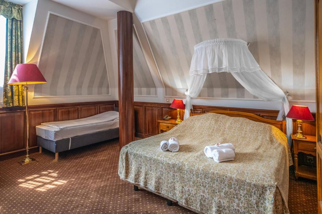 Postel nebo postele na pokoji v ubytování Kastélyhotel Sasvár Resort