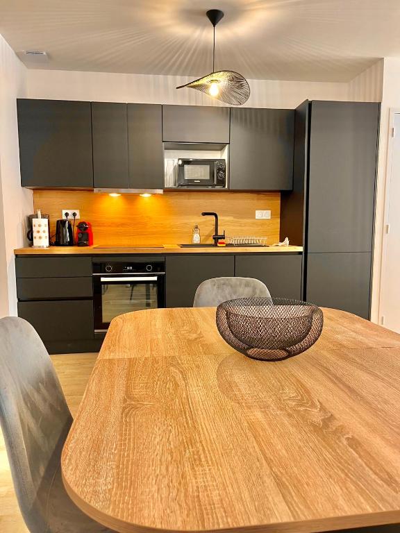 Il comprend une cuisine avec une table et des chaises en bois. dans l'établissement T2 Rez-de-chaussée, Le Victor Hugo, à Cancale