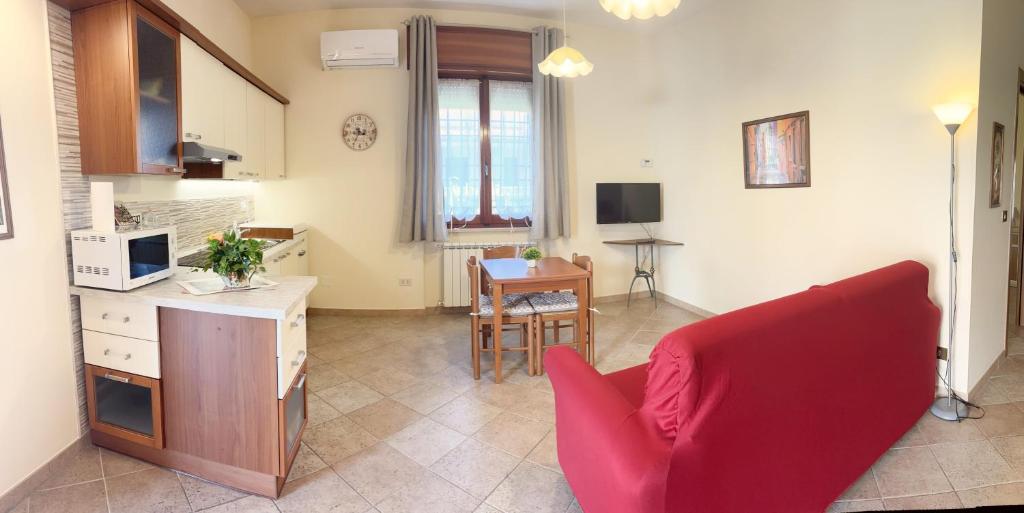 salon z czerwoną kanapą i stołem w obiekcie A casa di Iole w mieście Fiumicino