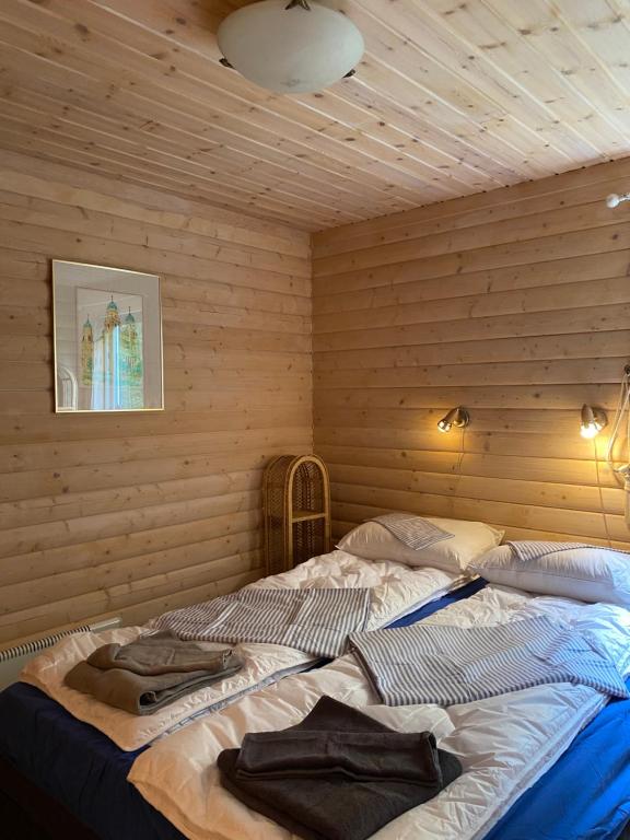 TöcksforsにあるKoselig hytte i Sverige 20 minutter fra norskegrensen Ostervallskogの木製の壁に大きなベッドが備わるベッドルーム1室