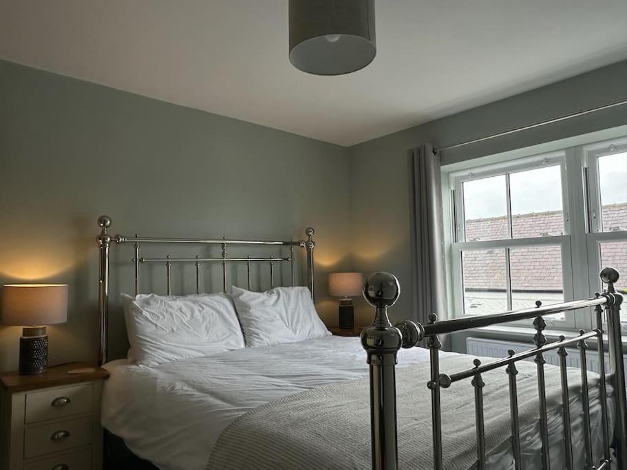 Un dormitorio con una cama con almohadas blancas y una ventana en Church walk view apartment Filey, en Filey