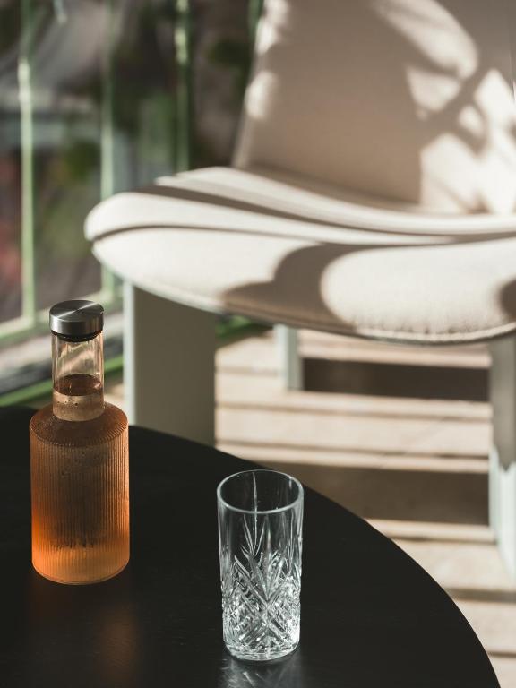 a glass sitting on a table next to a bottle at Hôtel Liautaud Rooftop Cassis in Cassis