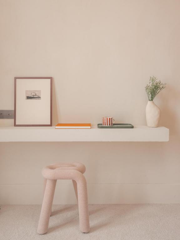 a pink stool in front of a white shelf at Hôtel Liautaud Rooftop Cassis in Cassis