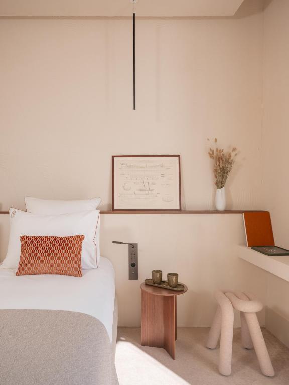 a bedroom with a bed and a table at Hôtel Liautaud Rooftop Cassis in Cassis