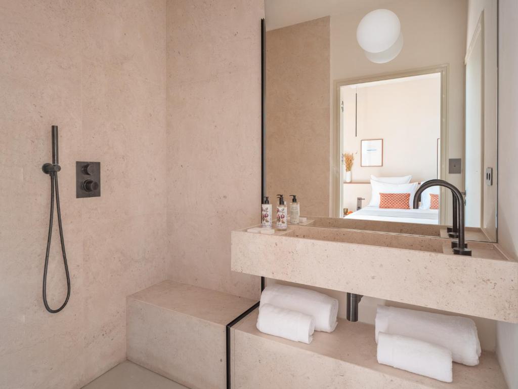 a bathroom with a sink and a mirror at Hôtel Liautaud Rooftop Cassis in Cassis