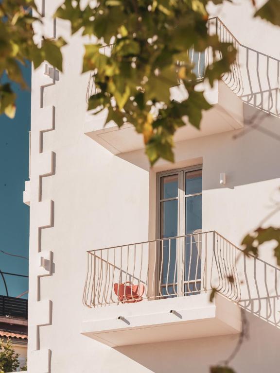 a white building with a balcony and a window at Hôtel Liautaud Rooftop Cassis in Cassis