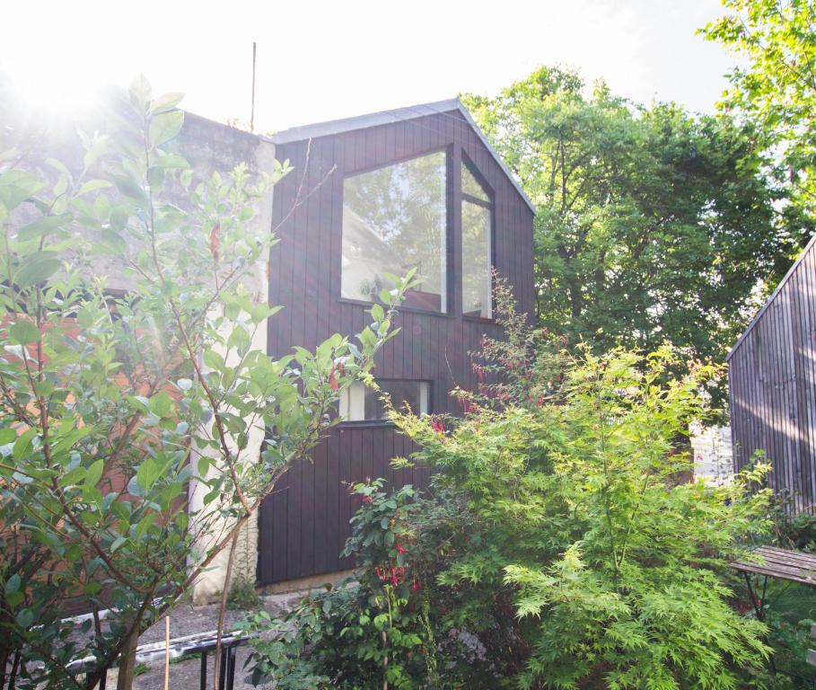 a timber house with a large window in a garden at Bright & Eco-Friendly Wooden Home, A Peaceful Retreat Near Paris in Montreuil