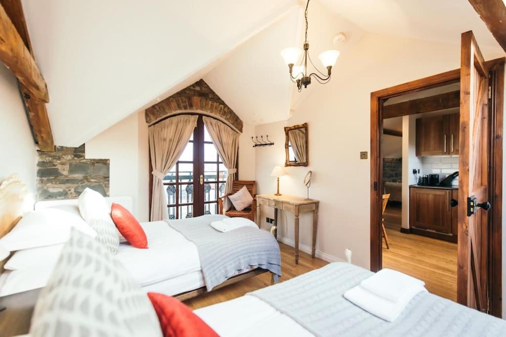 a bedroom with two beds and a table at Willows, 3 Bed Cottage with Spacious Kitchen in Lisburn