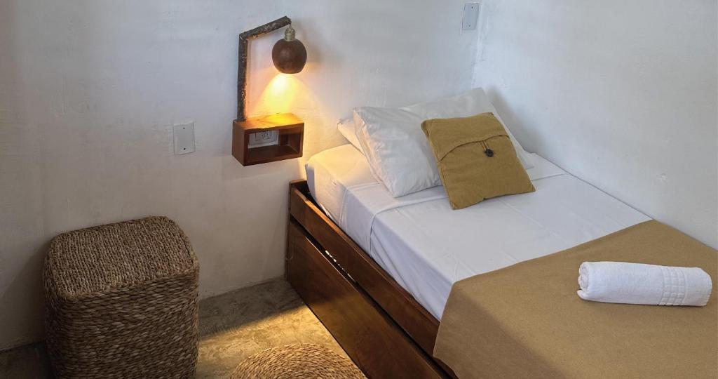 a small bedroom with a bed and a chair at Mandala Hostel Jeri in Jericoacoara