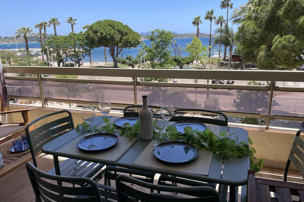 - une table avec des verres à vin et une bouteille sur le balcon dans l'établissement Studio with large balcony - sea view, à Bandol