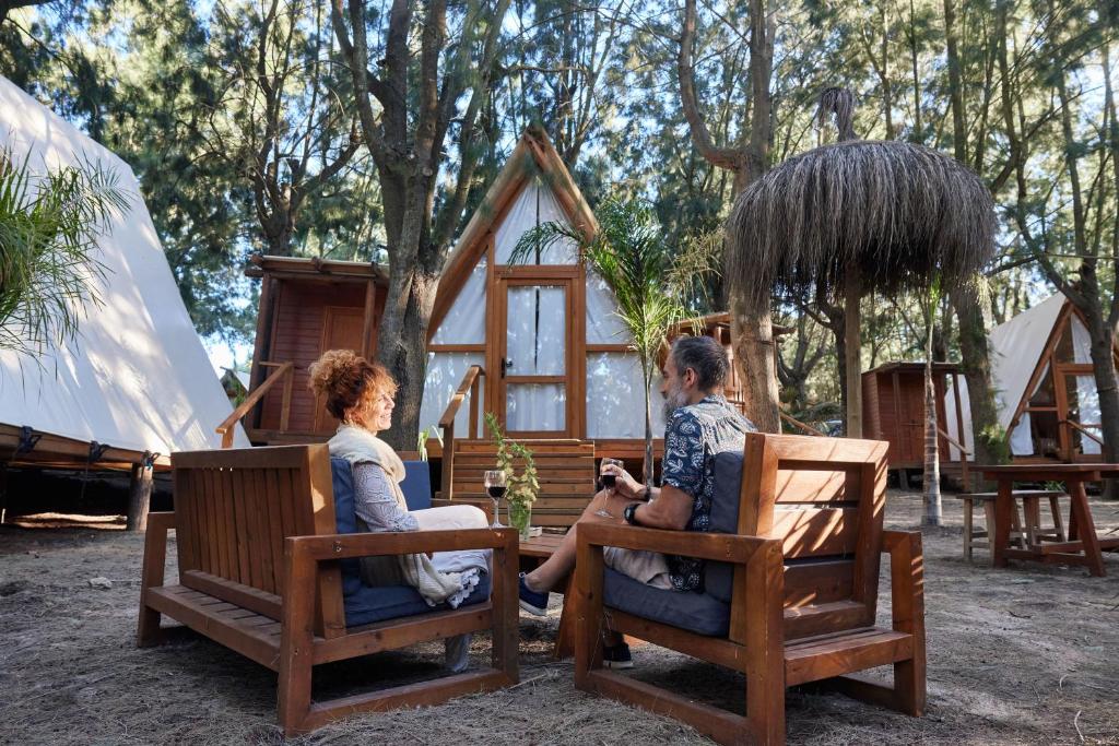 Dos mujeres sentadas en sillas frente a una casa en TAIGA Tarifa Punta Paloma, en Tarifa
