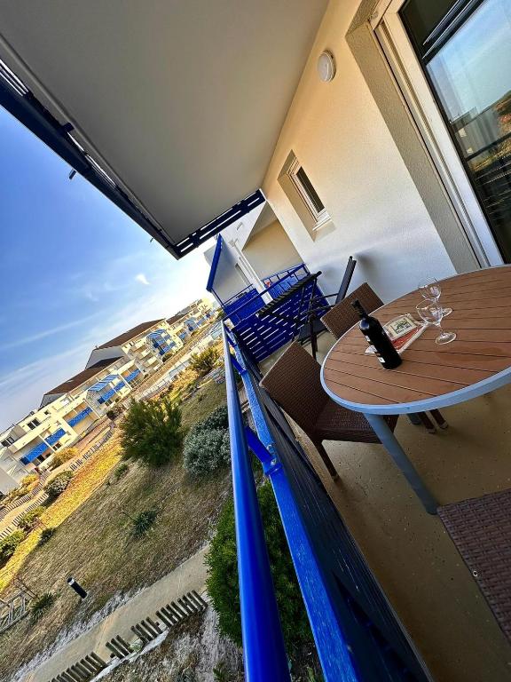 d'un balcon avec une table et une vue sur la plage. dans l'établissement Tout près des vagues, à Lacanau