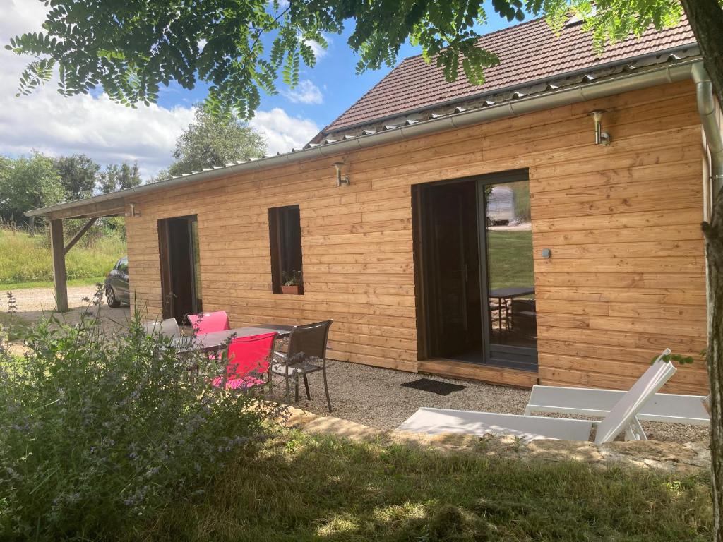 una casa de madera con una mesa y sillas delante de ella en Lodge détente et spa, en Le Puley