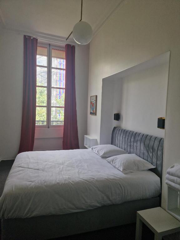 une chambre avec un grand lit et une fenêtre dans l'établissement Le Circus, à Paris