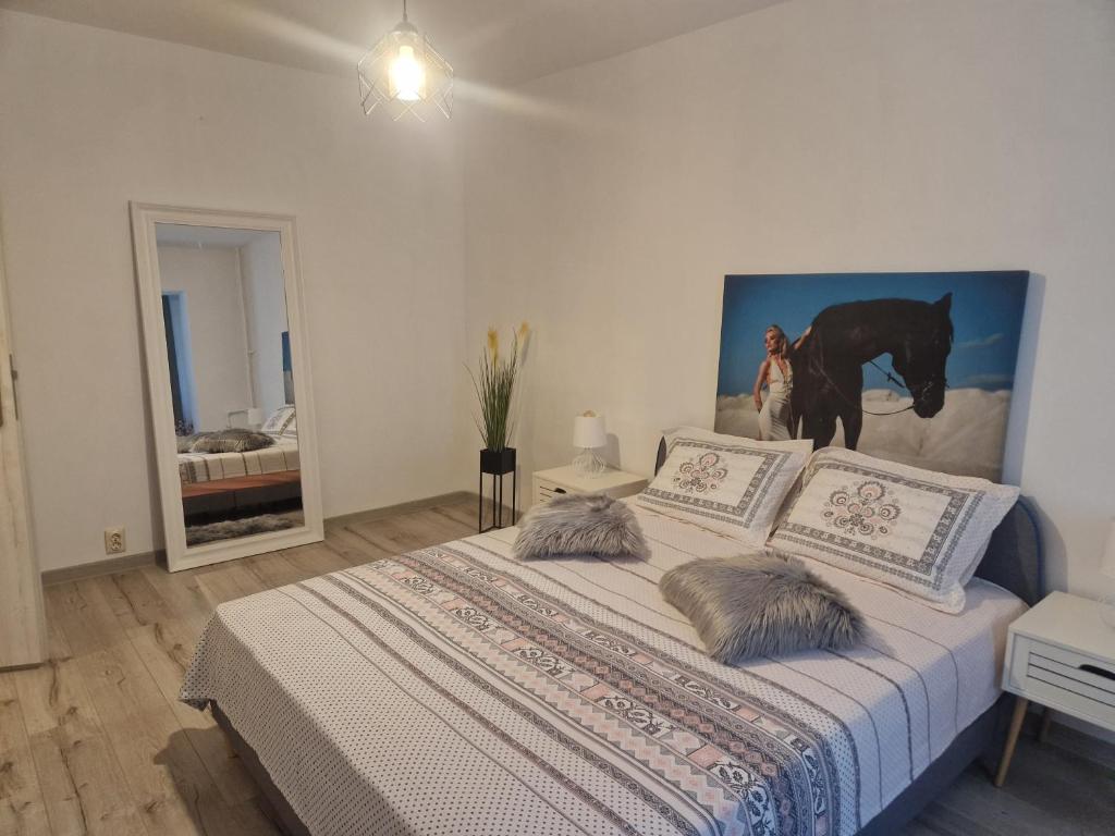a bedroom with a bed with a painting of a horse at Apartament de lux in Craiova