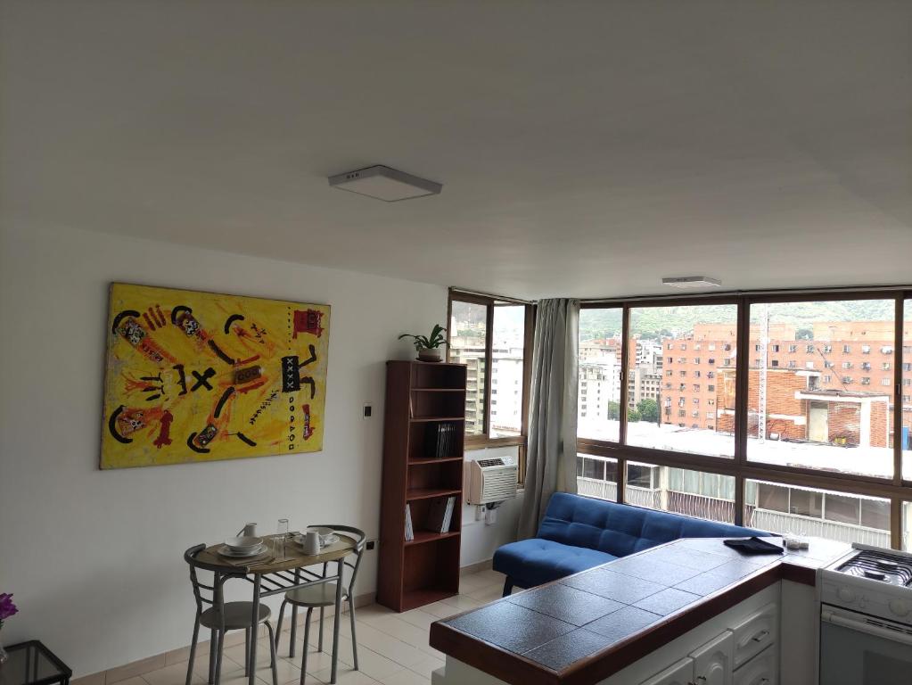 un salon avec un canapé bleu et une table dans l'établissement Apartamento cerca del Boulevard de Sabana Grande y zona comercial, à Caracas