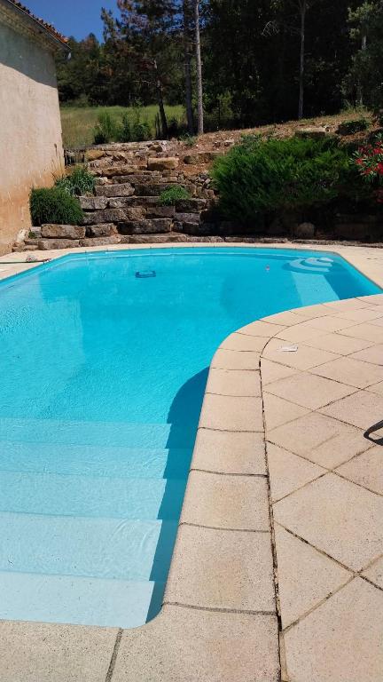 une grande piscine bleue à côté d'une maison dans l'établissement Domaine Castel Negre Alet Les Bains, à Alet-les-Bains