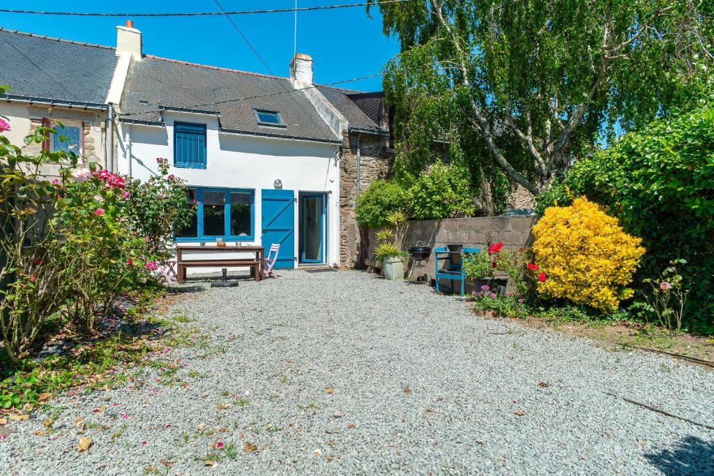 une maison avec une porte bleue et une allée en gravier dans l'établissement Casa Azul - Maison proche de la plage, à Sarzeau