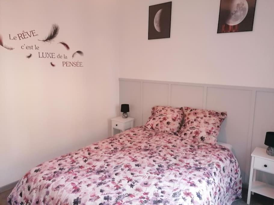 une chambre avec un lit avec un couvre-lit fleuri dans l'établissement Le Logis du Lion - centre historique Belfort, à Belfort