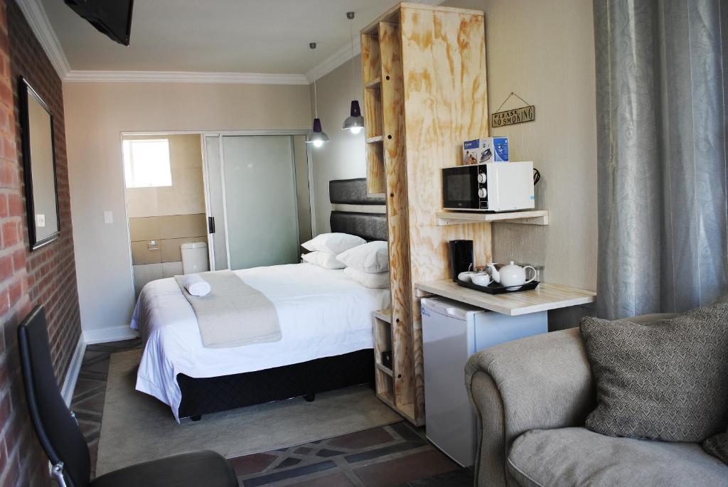 Habitación pequeña con cama y microondas en B and B Sandton, en Johannesburgo